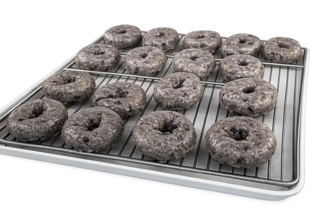 Powdered dark cake donut rings arranged on a wire rack at Atlanta Donuts.